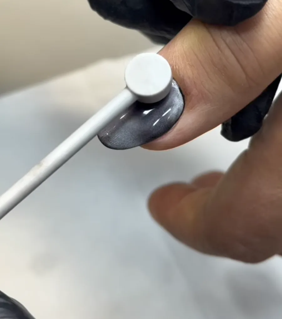 Pose d'un vernis effet cat eye sur un ongle, à la pince aimantée